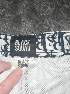 Black Quad weiße Badeshort mit schwarzen Schriftzügen