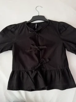 schwarze Bluse mit Puffärmeln und Schleifen
