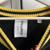 schwarzer pullover mit gelben details und fransen