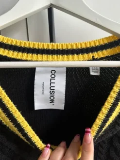 schwarzer pullover mit gelben details und fransen